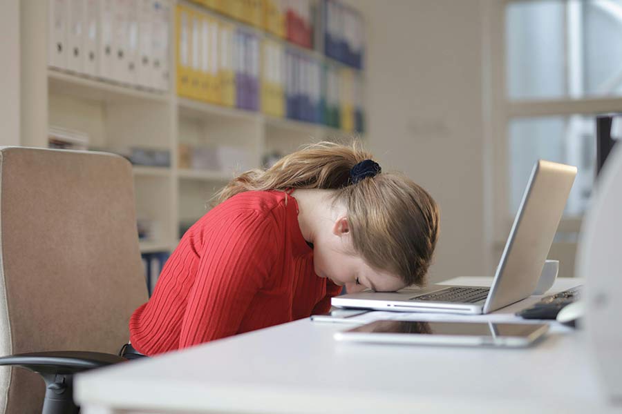 Disaster Recovery blog image of a woman with her head resting on her laptop in defeat. Photo by Andrea Piacquadio: https://www.pexels.com/photo/woman-sitting-on-chair-while-leaning-on-laptop-3791136/